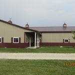 A large pole barn-style building with beige and brown siding, multiple windows, cupolas on the roof, and a covered entryway sits on a green lawn with a gravel driveway. The date 16/09/2020 is visible in the corner. Kentucky Builders And Excavating
