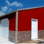 A red metal pole barn with a white door, two white garage doors, and a stone-patterned lower exterior sits under a blue sky with scattered clouds. Kentucky Builders And Excavating