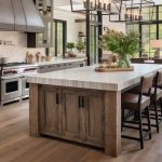 Spacious farmhouse kitchen with large center island opening to living area, white cabinets, natural light from large windows, efficient layout for family of four